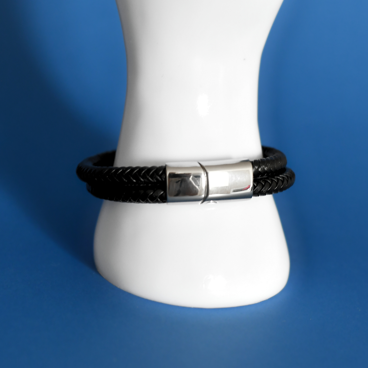 ACUIR genuine leather braided bracelet in black with stainless steel clasp for men on hand with clasp shown
