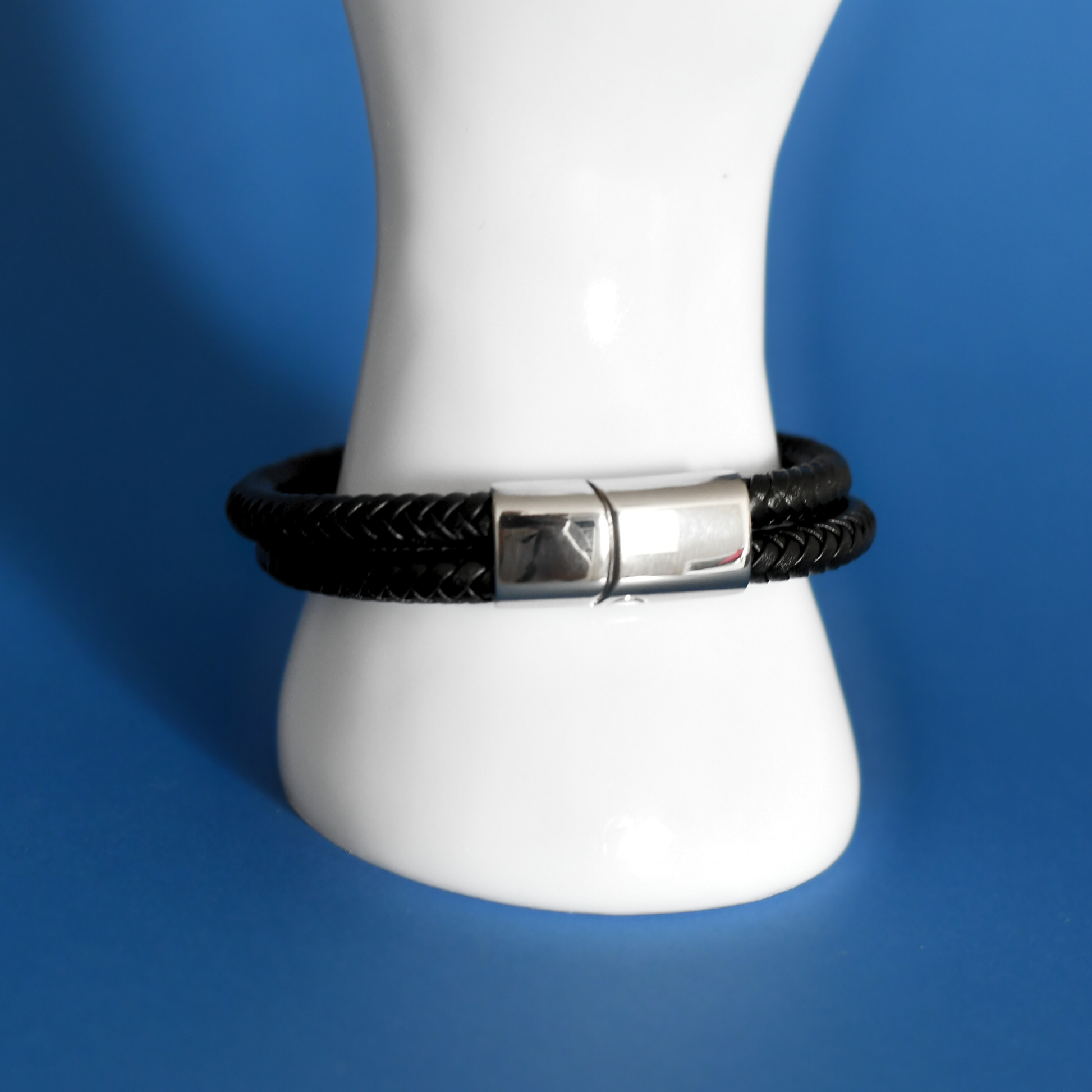 ACUIR genuine leather braided bracelet in black with stainless steel clasp for men on hand with clasp shown